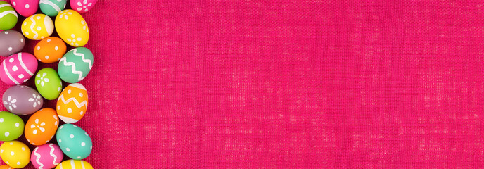 Colorful Easter Egg banner with side border against a vibrant pink burlap background. Above view with copy space.