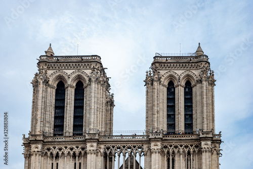 Photo of the towers of the Notre Dame cathedral in Paris, France on a cloudy day