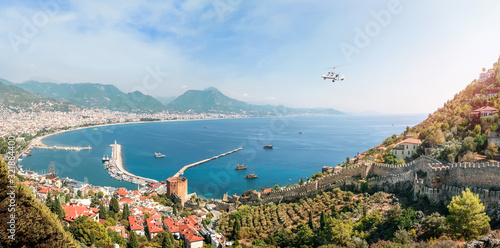 Autogyro with two tourists flies over the beach of Alanya, panoramic view photo