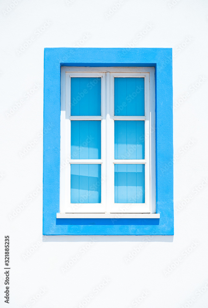 A closed window with a blue frame in Albufeira, Algarve, Portugal A closed window with a blue frame in Albufeira, Algarve, Portugal