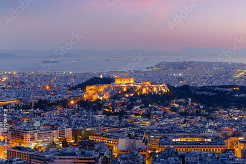 Amazing aerial view of Athens  Greece. Night over ancient Acropolis  ruins. Parthenon  the Icon of the hellenic civilization  Aegean sea on background. Traditional mediterranean architecture 