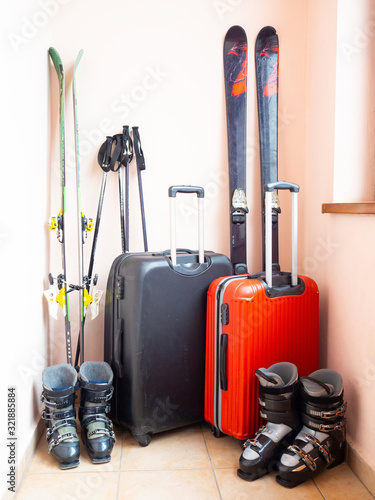 Ski and snowboard equipment. Boots, skis, sticks, red and black suitcases. Concept of travel, recreation and sports. Close up