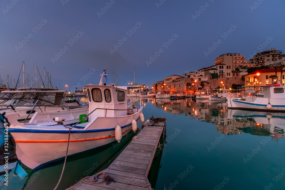 Panoramic view of beautiful sunset in Koules Fortress (Rocca a Mare), Crete island. Yachts reflecting in the mirror of water near Venetian old harbor in Heraklion city. Amazing destination in Greece