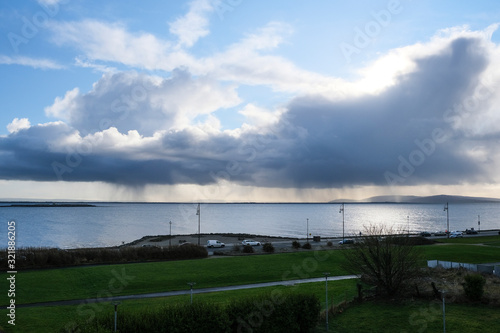 Rain clouds pouring over the ocean with blue sky. Taken on Salthill promenade in Galway, Ireland © Michaella