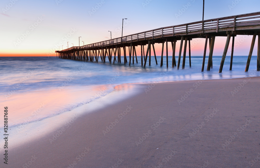 Fototapeta premium Fishing Pier at Sunrise at Virginia Beach, Virginia, USA. Virginia Beach, a coastal city in southeastern Virginia, lies where the Chesapeake Bay meets the Atlantic Ocean.