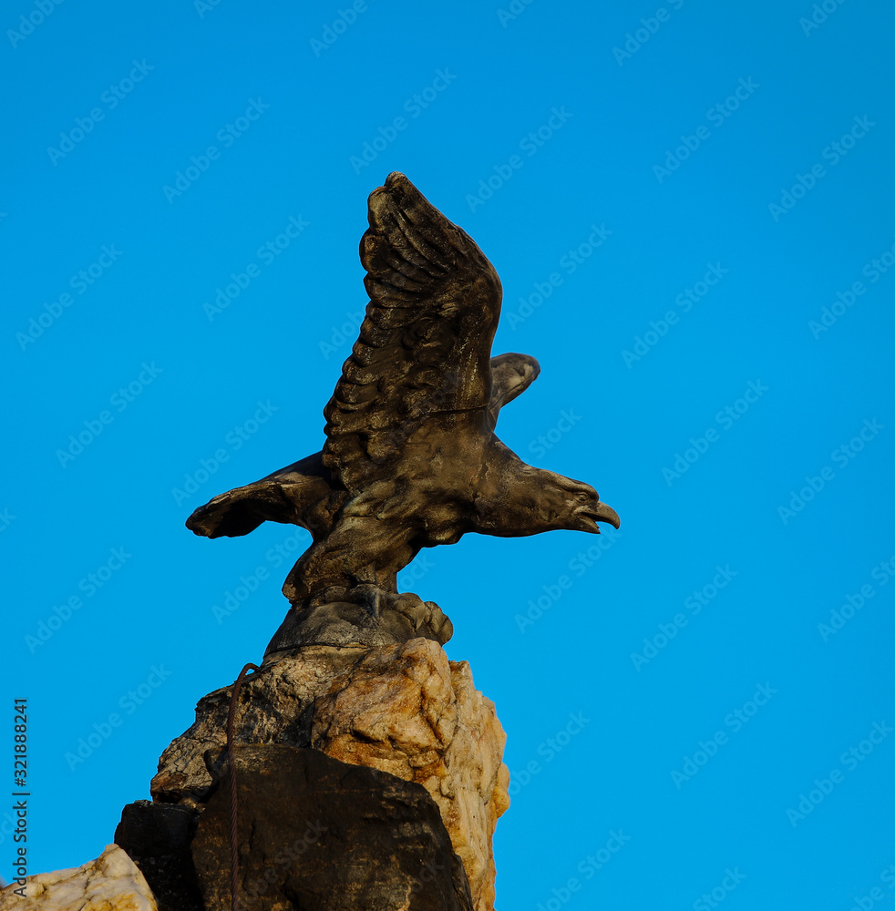 Escultura de un águila encima de una roca con las alas extendidas en Austria. 