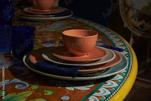 Still life. There are a mug and saucer, plates of various sizes, a napkin and blue glasses on the table
