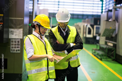 Waist up workers check checklist in factory photo