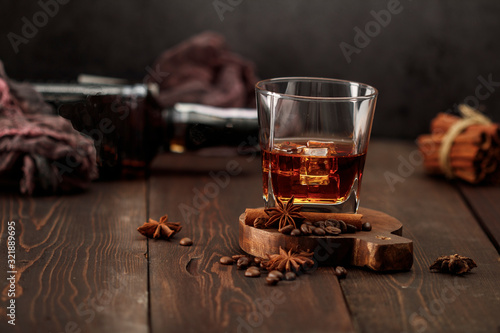 Whiskey with ice or brandy in a glass on a rustic background. Whiskey with ice in a glass. Whiskey or brandy. Selective focus.
