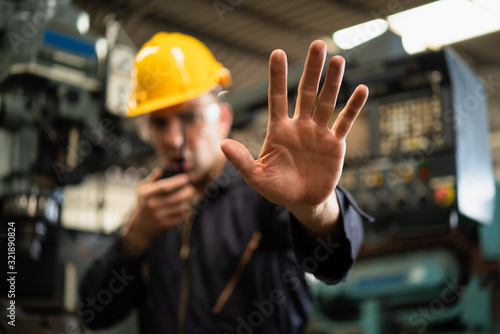 Canvastavla Industrial worker in factory site gesture keep out or stop while communicating with a walkie talkie