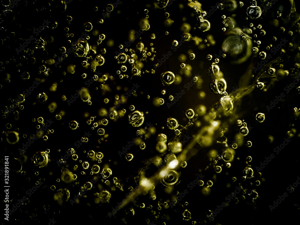 Water bubbles frozen in ice. White bubbles frozen in black ice. Hundreds of air bubbles are locked in the frozen water with no backlight.