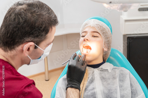 Dentist doctor looks into the patient mouth