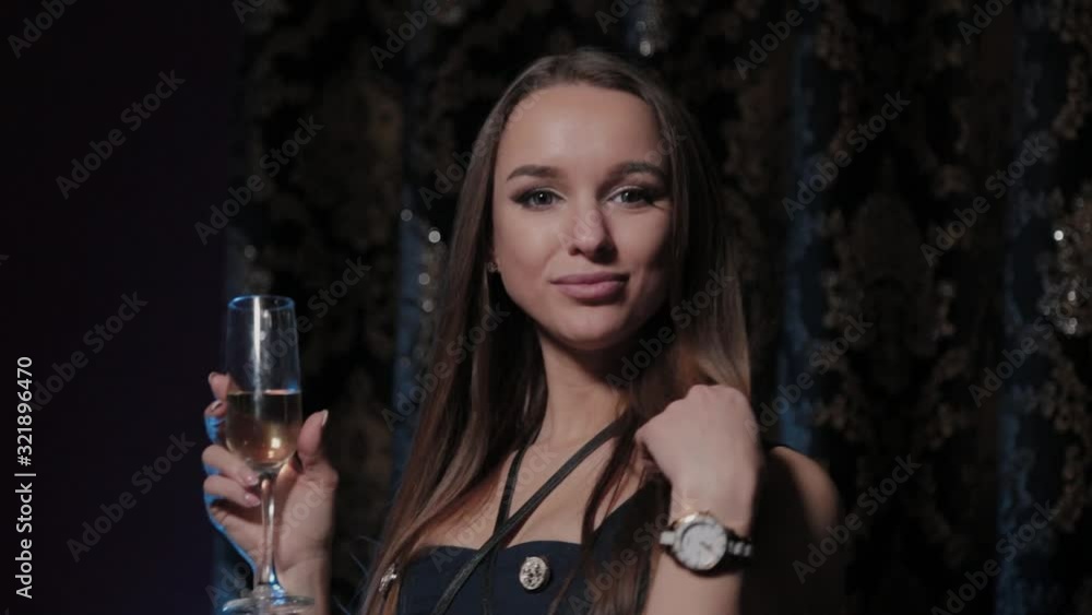 Beautiful young woman with a glass of champagne in a restaurant interior. Beautiful young woman with a glass of champagne in a restaurant interior.