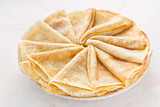 Russian pancakes (crepes) with powdered sugar - traditional Maslenitsa (Shrovetide) meal on white background.