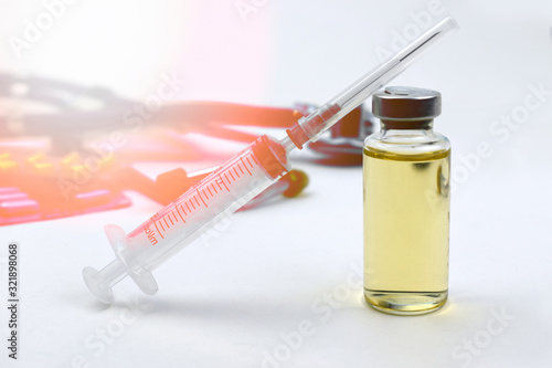 Vaccine vial with syringe over medical treatment on white background. Vaccination or antibiotic health care. Virus epidemic dangerous concept. Sun light effect.