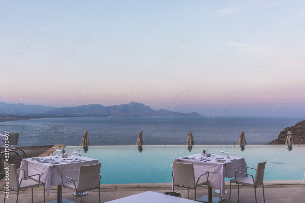 Fototapeta premium Beautiful sea view by an infinity pool deck during the blue hour.