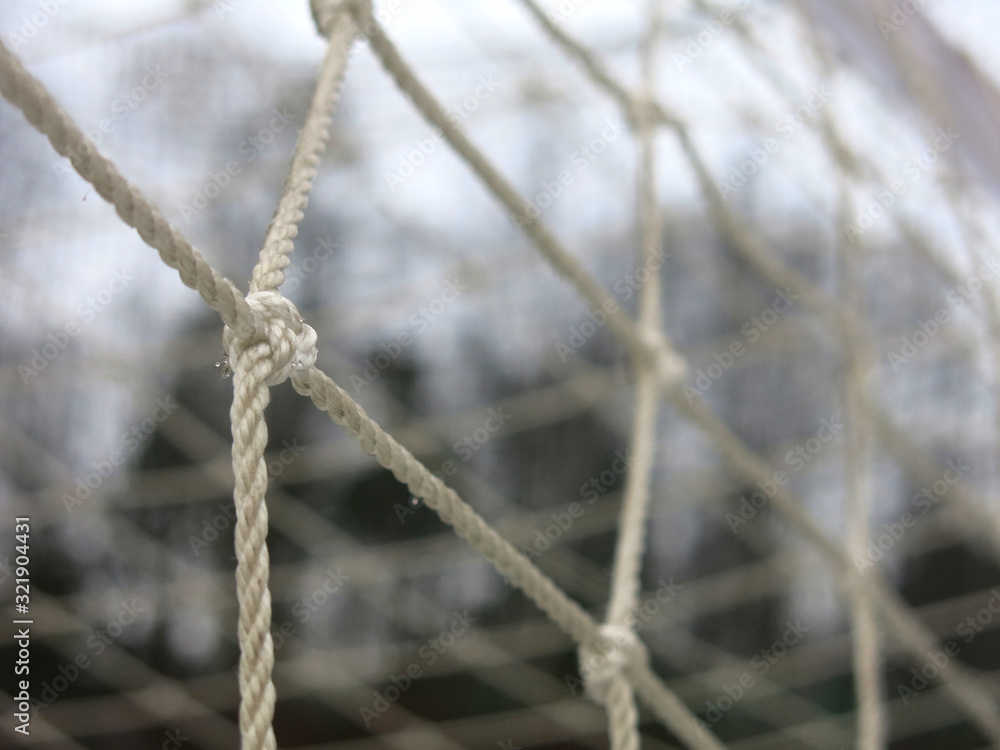 football goal with a grid close-up on a snow-covered sports field