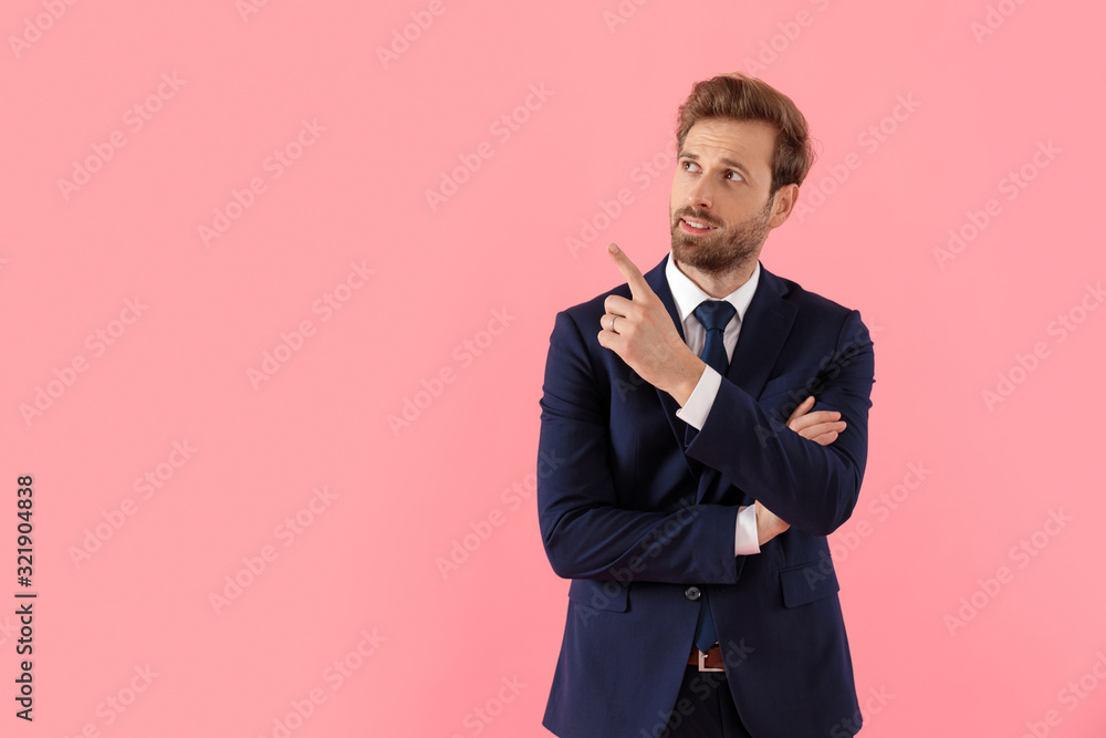 Cheerful businessman pointing up with his hand crossed Cheerful businessman pointing up with his hand crossed