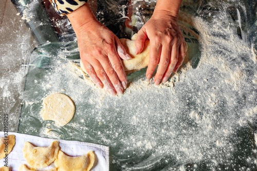 The housewife hands knead the dough for making dumplings in Ukrainian national cuisine. photo