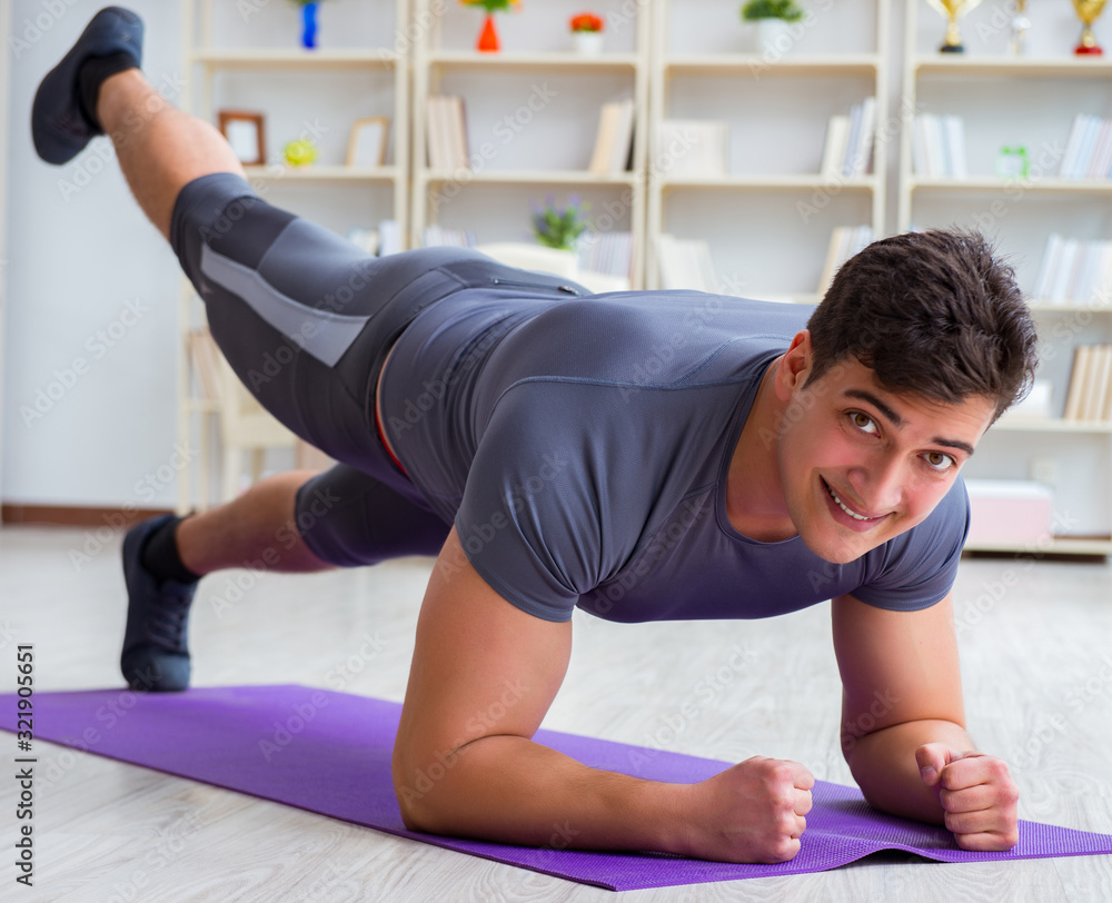 Young man exercising at home in sports and healthy lifestyle con Young man exercising at home in sports and healthy lifestyle con