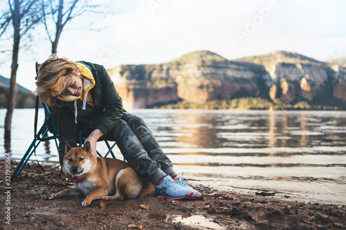 tourist traveler girl together dog on background mountain lake, fun smile woman hugging puppy pet nature, friendship love concept