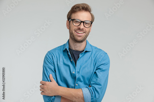 excited young casual man laughing and crossing arms photo