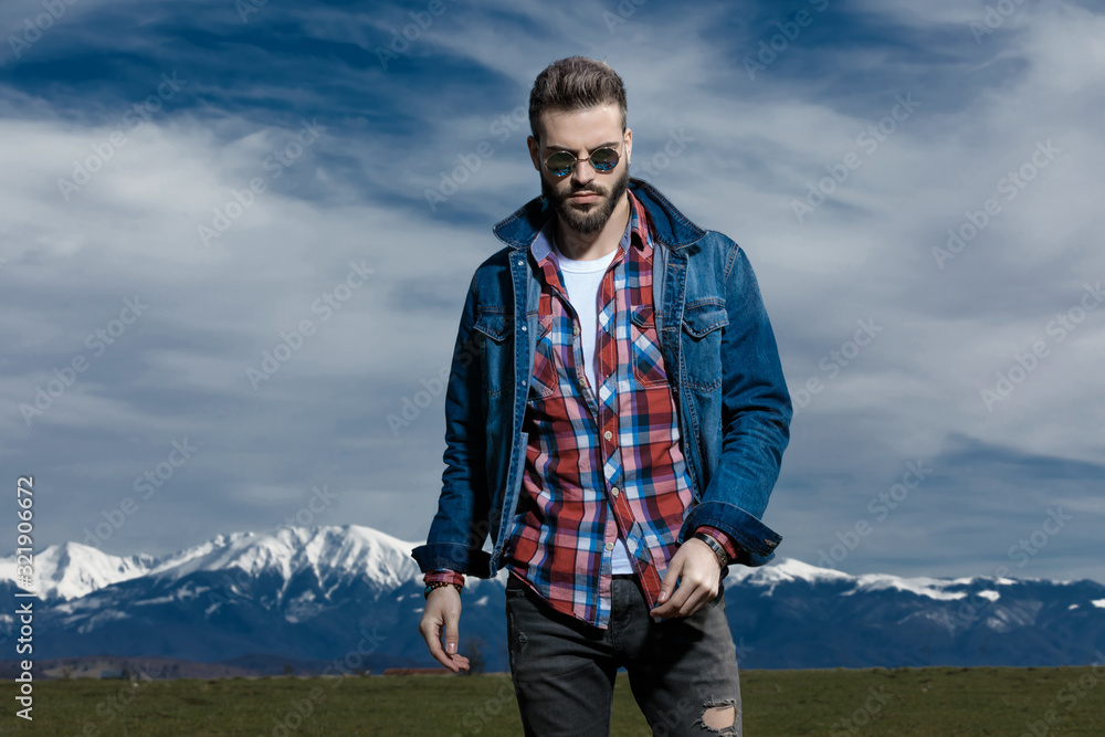 Tough man while wearing jeans jacket and sunglasses