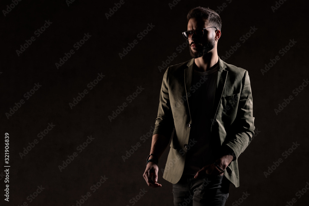 cool unshaved guy walking in a fashion light in studio cool unshaved guy walking in a fashion light in studio