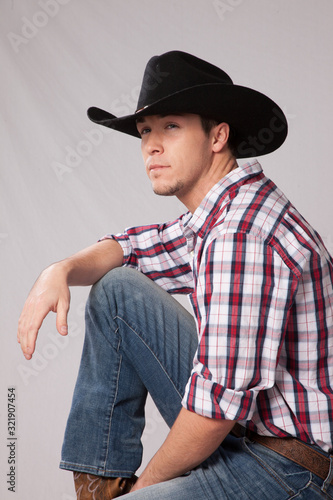 Pensive Cowboy in hat and plaid shrit photo