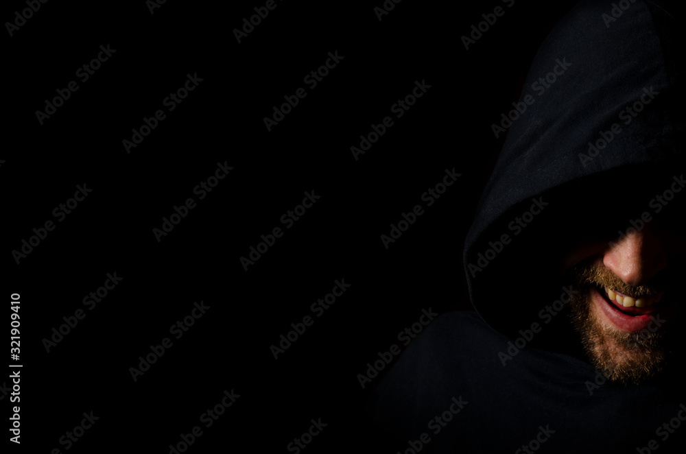 evil face a man in the dark. beard smile evil face a man in the dark. beard smile