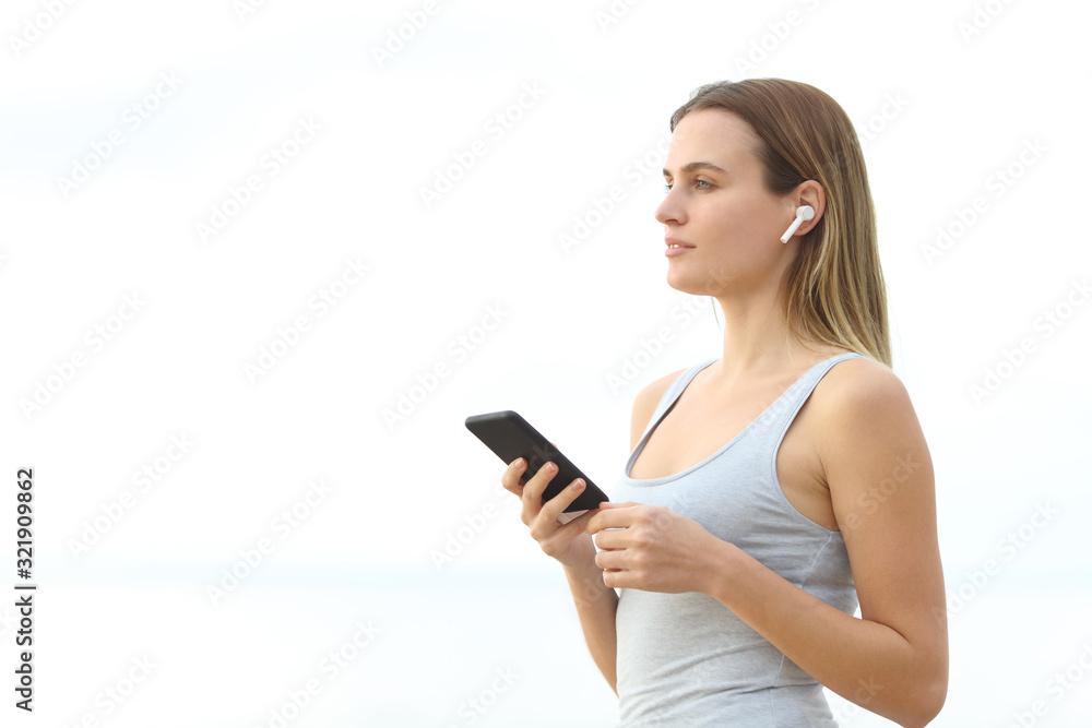 Girl listens to music wearing earbuds holding phone