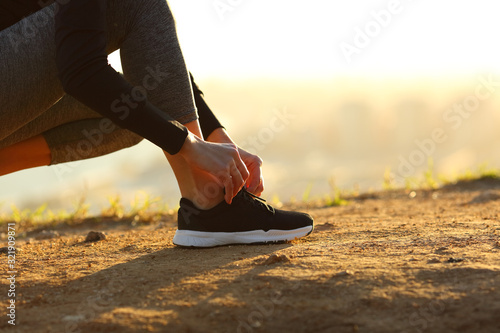 Close up of runner hands tying shoelaces of shoes