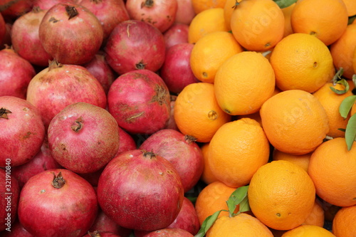 Fototapeta Naklejka Na Ścianę i Meble -   Pomegranates and oranges in the market. Colored fruit background, pattern, banner.