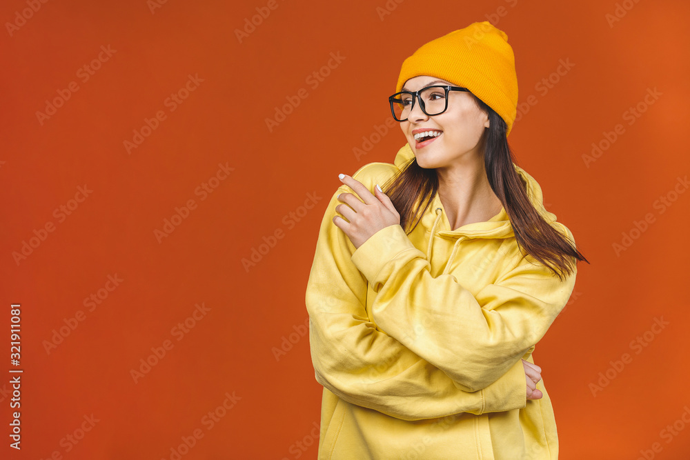 People, youth, leisure and lifestyle concept. Fashionable beautiful young Caucasian young female student wearing stylish clothing laughing, pointing finger. Isolated over orange. People, youth, leisure and lifestyle concept. Fashionable beautiful young Caucasian young female student wearing stylish clothing laughing, pointing finger. Isolated over orange.
