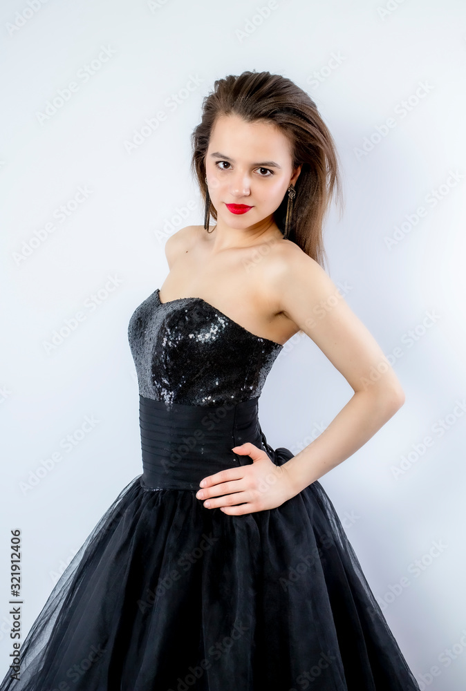 young lady posing in fashion long black dress. Isolate