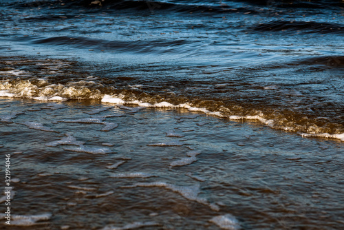 Waves with foam on the shore of the cold Baltic Sea