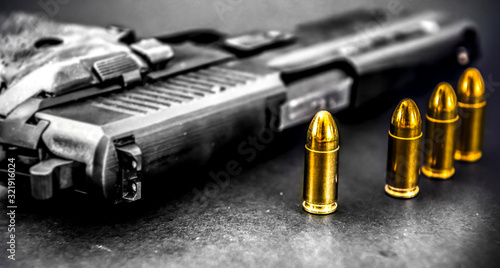 Bullets and handcuffs. Close-up of 9mm pistol. Gun and weapon with bullets amunition on black backround. photo