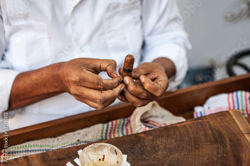Cuban man bundling a cigar