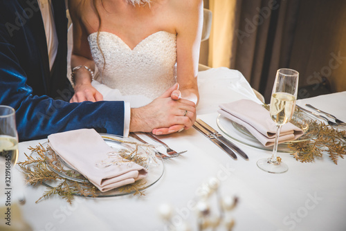 Wedding flowers on a table (bride and groom in a background)