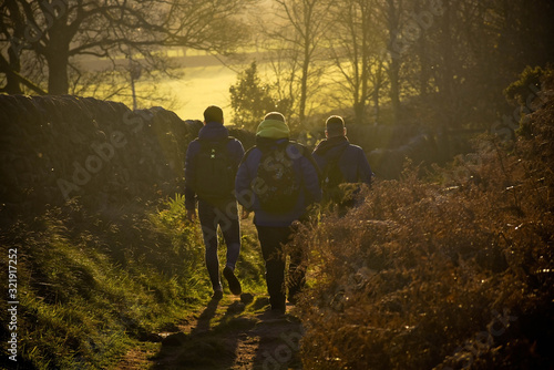 Three men hiking in a natural background with yellow light