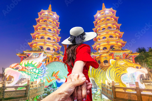  Asian women visit Dragon and the tiger pagoda at the lotus pond and the reflections at night. photo