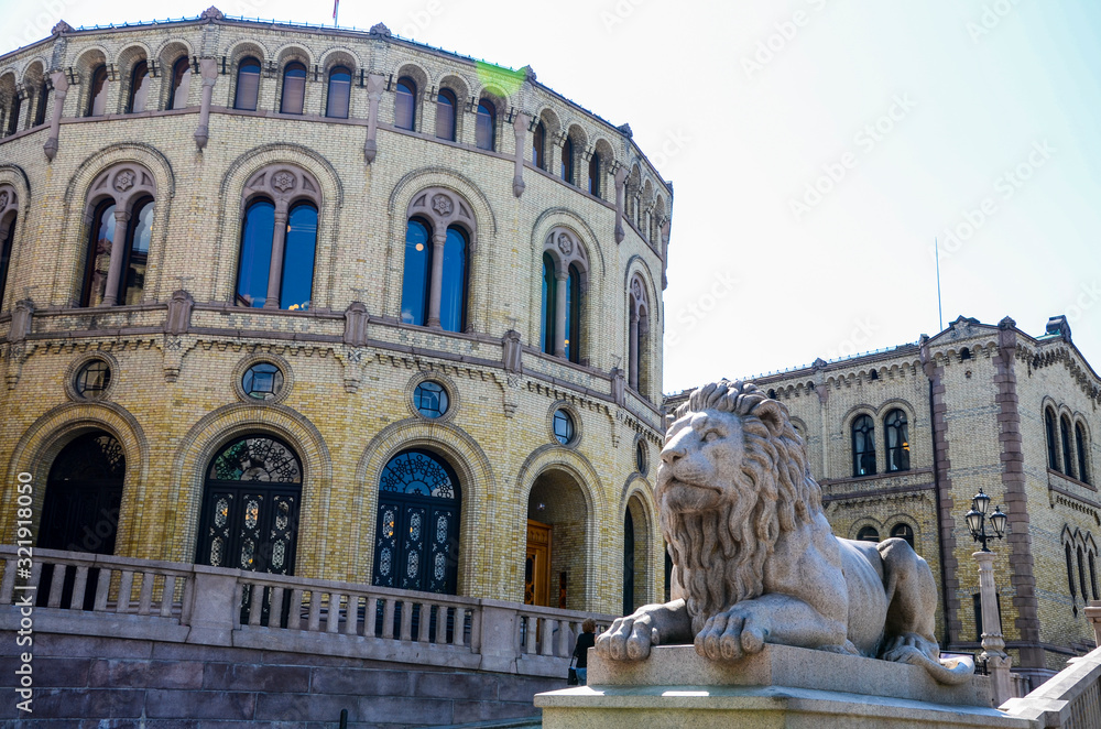 Building of Norwegian Parliament in Oslo with one of lions sculptures outside the building. 