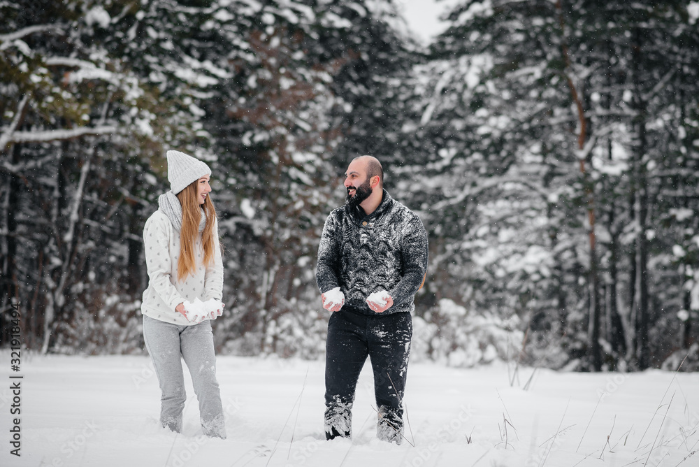 Couple playing with snow in the forest