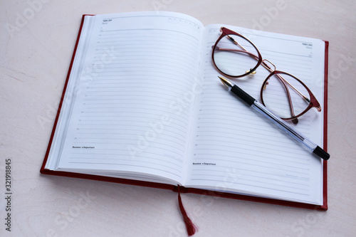 Open diary for notes, glasses and pen