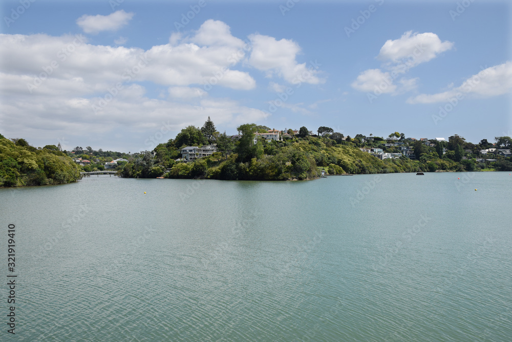 Green headland on a lake with houses on it