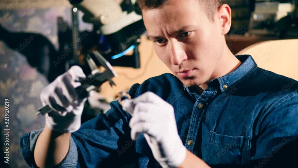Jeweler measures a diamond on a ring. Jeweler measures a diamond on a ring.