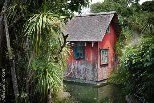 Fotografie Tiny run-down red shack in the middle of a jungle setting