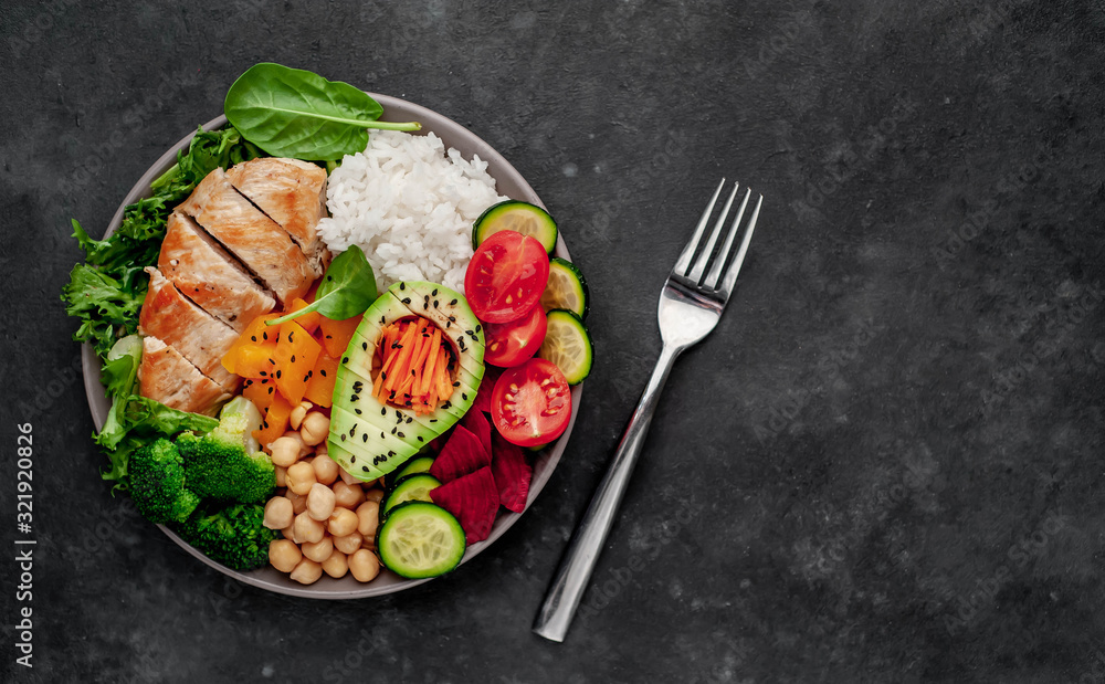 Bowl Buddha. rice, chicken breast, broccoli, pumpkin, avocado, chickpeas, carrots, cucumber, beets, a stone background  with copy space for your text