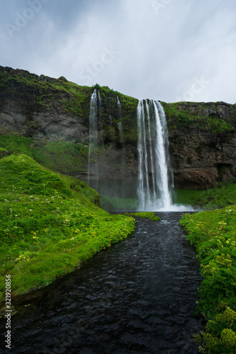 Seljalandsfoss in Iceland, on a cloudy day with river