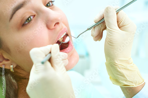 Girl sitting at dental chair with open mouth during oral check up while doctor. Visiting dentist office. Dentistry concept.